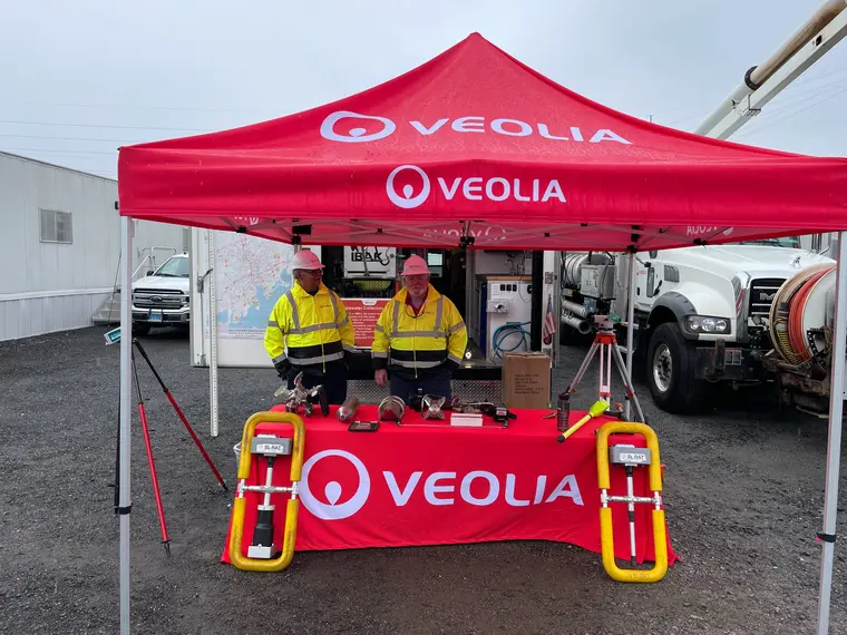 Utility field team beneath a red canopy